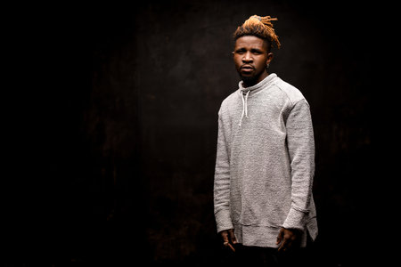 Afro american guy posing on a dark background
