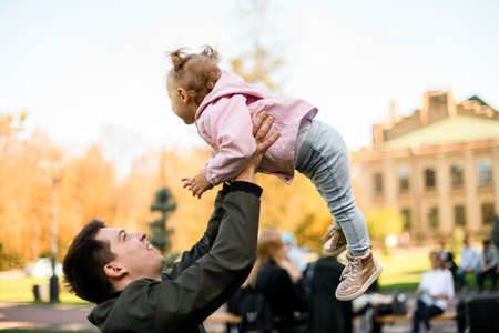 Father playing with daughter holding her in the armsの写真素材