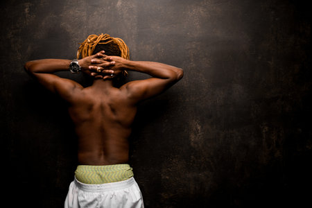 Afro american guy standing with hands behind his head