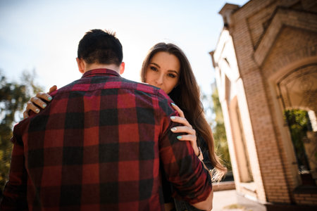 Woman looking over her husband s shoulder in the autumn park