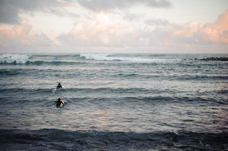 Man and woman swimming on surf boardsの写真素材