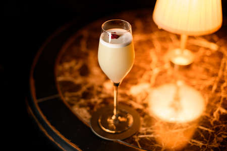 Tasty alcohol cocktail with pink flower stands on a tableの写真素材