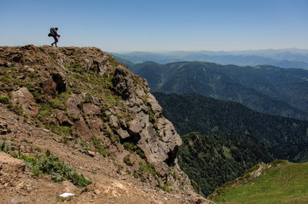 Traveller walks to a high mountain cliffの写真素材