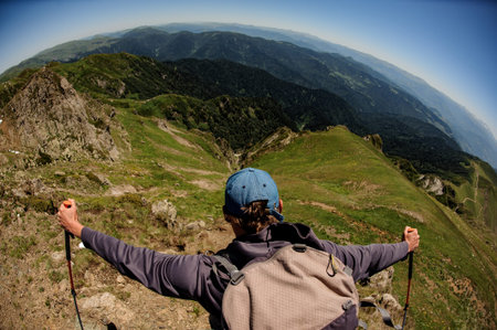 Male traveller conquering the mountain top and looking at amazing sceneryの写真素材