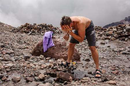 Male tourist washing his face with waterの写真素材