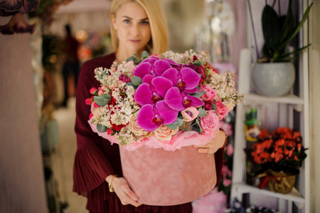 Blond girl standing with giant bouquet in box