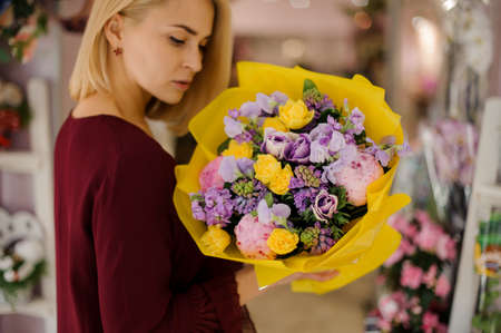 Smiling female posing with colorful flower bouquetの写真素材