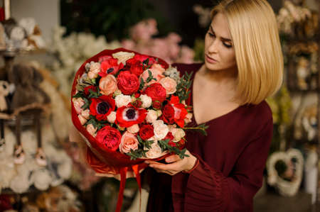 Woman holds bouquet with poppies and rosesの写真素材