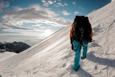 Male journeyman hikes up the snowy mountain