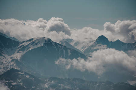 Landscape of mountain top peeking out from cloudsの写真素材