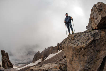 Male traveller standing on top of the rockの写真素材