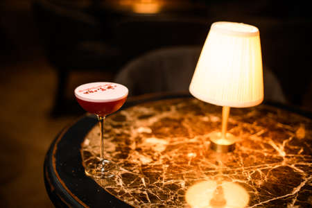 Close-up of fancy cocktail standing on table with lampの写真素材