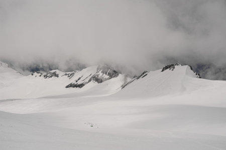 Landscape of the rocky mountain slope covered by snow under the sky on the way on meteostation in...