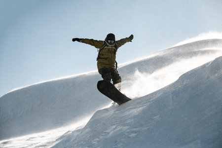 Freeride snowboarder jumping down the mountain snowcovered slope in the Goderdzi, Georgia in the...