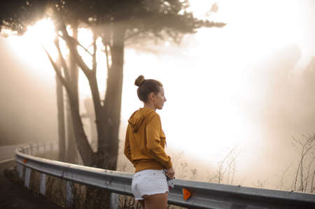 Girl in stylish clothes stands in forestの写真素材