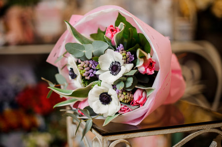 Bunch of poppies in pink paper on tableの写真素材