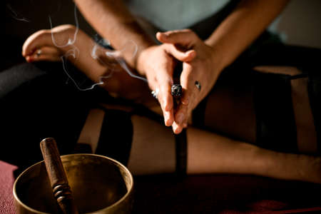 Young woman sitting in yoga pose and hold hands in front of herself.の写真素材