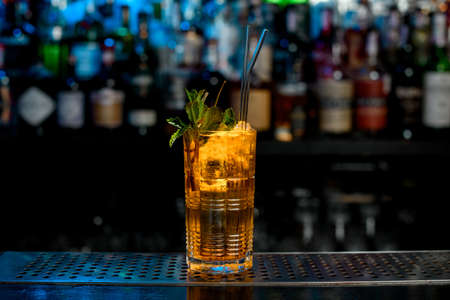 Glass of ice drink decorated by mint leaves, berries and glass sticks.の写真素材