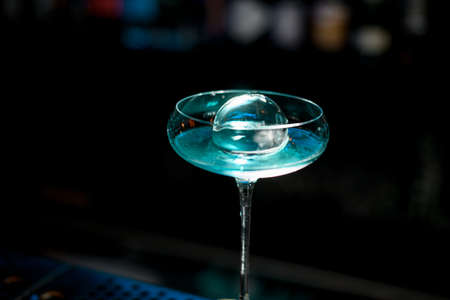 Close-up of very beautiful glass with blue drink stand on bar.の写真素材