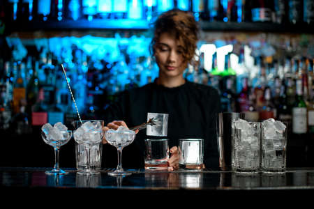 different glasses with ice stand on bar counter.の写真素材