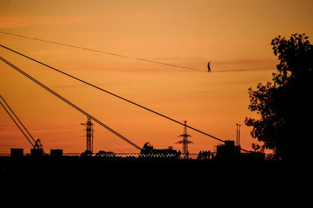 evening view of bridge with stretched sling along which man walks