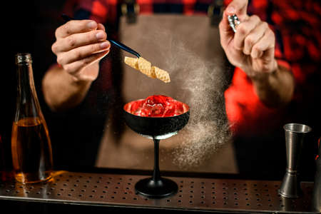close-up. Bartender gently decorates glass with cold drinkの写真素材