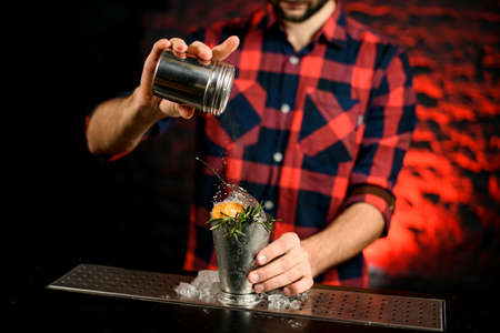 close-up of bartender decorated steel glass by sugar powderの写真素材