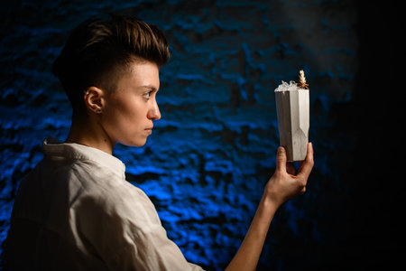 profile face of girl which holds in her hand ceramic glass with cold drink and look at it.
