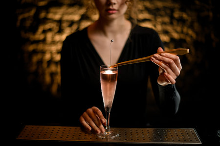 close-up girl at bar decorates by flower glass with light rose cocktail