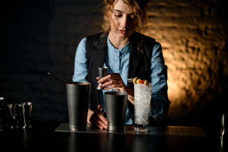 Several steel bowls and glass of ice stand on barの写真素材