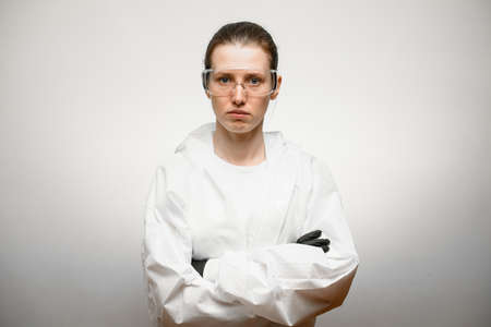 Female doctor in protective gear and goggles stay with crossed armsの写真素材