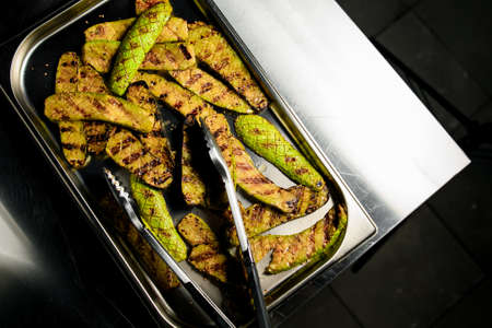 Close-up of tray with fried slices of zucchini on steel table.の写真素材