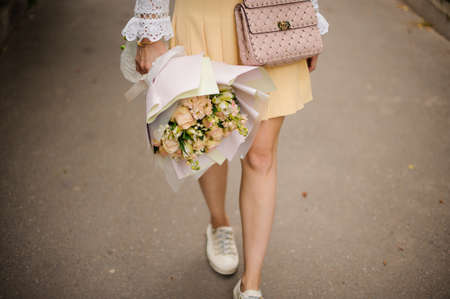 View of bouquet of roses in the hands of girl who walking in parkの写真素材