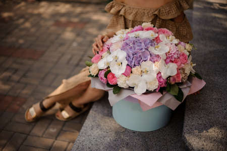 large bright flower arrangement in round box stands on the steps.の写真素材