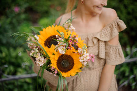 stylish bouquet with bright sunflowers in the hands womanの写真素材
