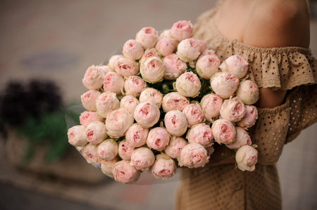 large bouquet of pastel pink peony in hands of beautiful girl.の写真素材