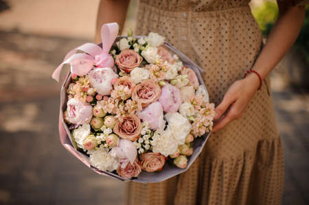 Beautiful delicate bouquet in pastel colors in the girls hand.の写真素材