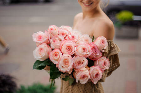 big bouquet of light pink roses in the hands of womanの写真素材