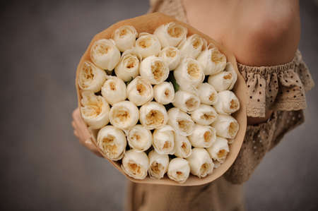 close-up of bouquet of white ranunculus in the hands of girlの写真素材