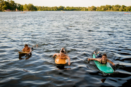 Front view of group of people which floating on surf boards on river water