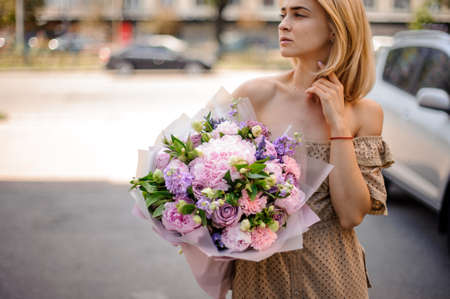 young attractive woman holds tender bouquet of flowersの写真素材