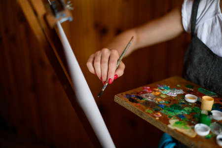 View of womans hand who paint with brush on canvasの写真素材