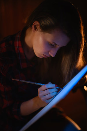 Close-up portrait of young beautiful woman with long hair who paints