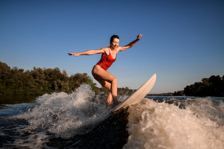 sports woman masterfully rides the wave on surfboard