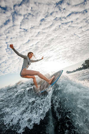 Sporty young woman ride wakesurf on the waveの写真素材