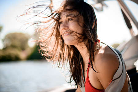 View on beautiful woman with brown hair developing in the wind at blurred background.の写真素材