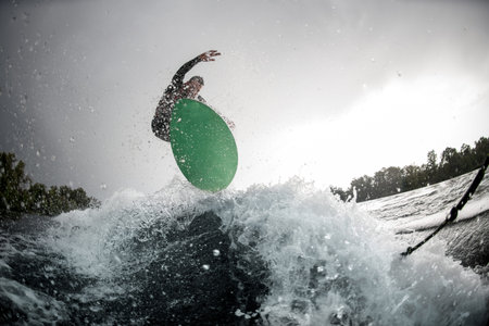 guy jumping on bright wakeboard down the river water