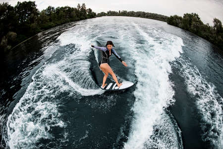 High angle view of young woman actively riding on waveの写真素材