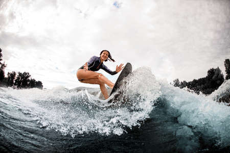 young cheerful woman is engaged in wake surfingの写真素材