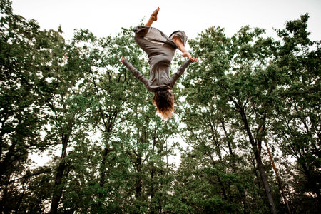 great view of beautiful woman perfectly jumps and performs trick upside down in the air